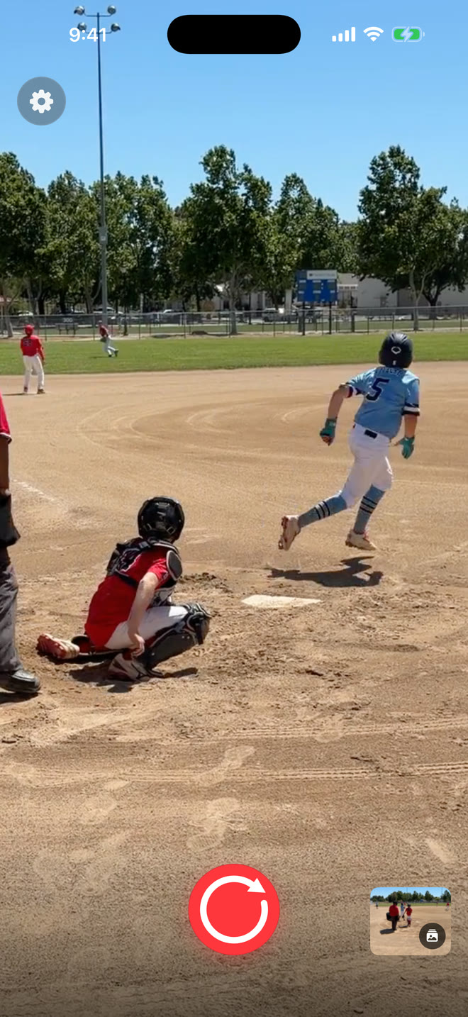 A baseball player running after a hit while Sideline Save is ready to record